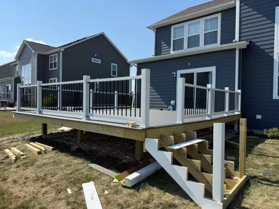 Elevated composite deck with white railing and exposed support framing during construction in Naperville, IL